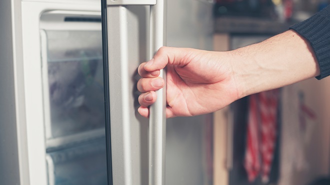 hand opening the door of a freezer